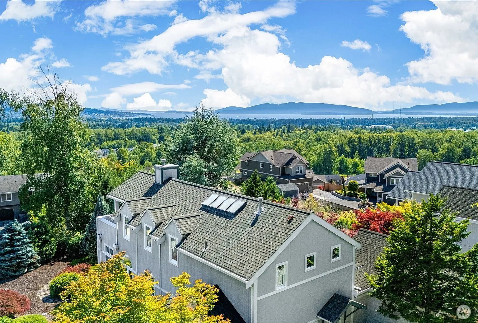 Aerial view from the property overlooking treetops toward Bellingham Bay and the San Juan Islands.