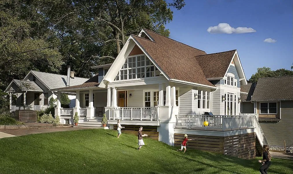 Craftsman-style home with a gabled entry and covered front porch, viewed from the front lawn.