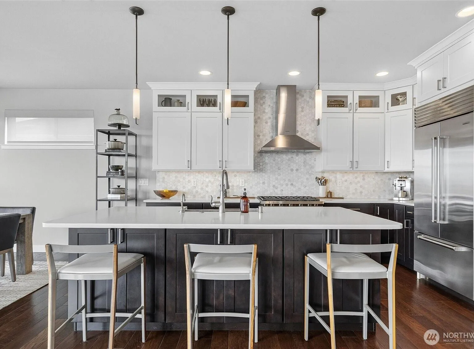 Kitchen with white shaker cabinets, a stainless range hood, and marble hexagon-tile backsplash.